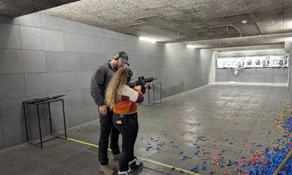Instructor guiding a tourist shooting a Glock 17 at Riga shooting range