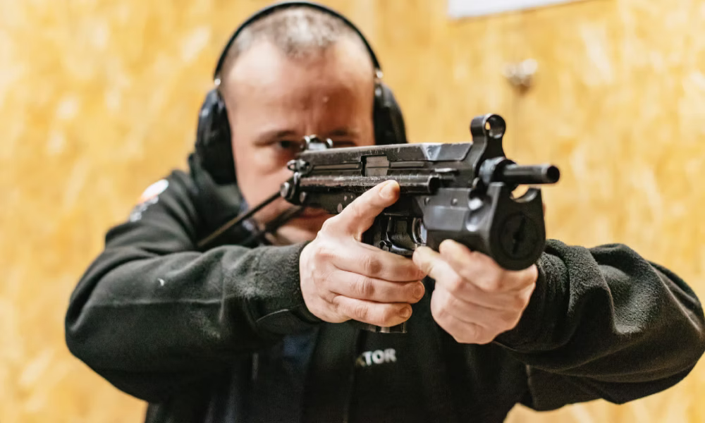 Tourist aiming a firearm at an indoor shooting range in Gdańsk, Poland